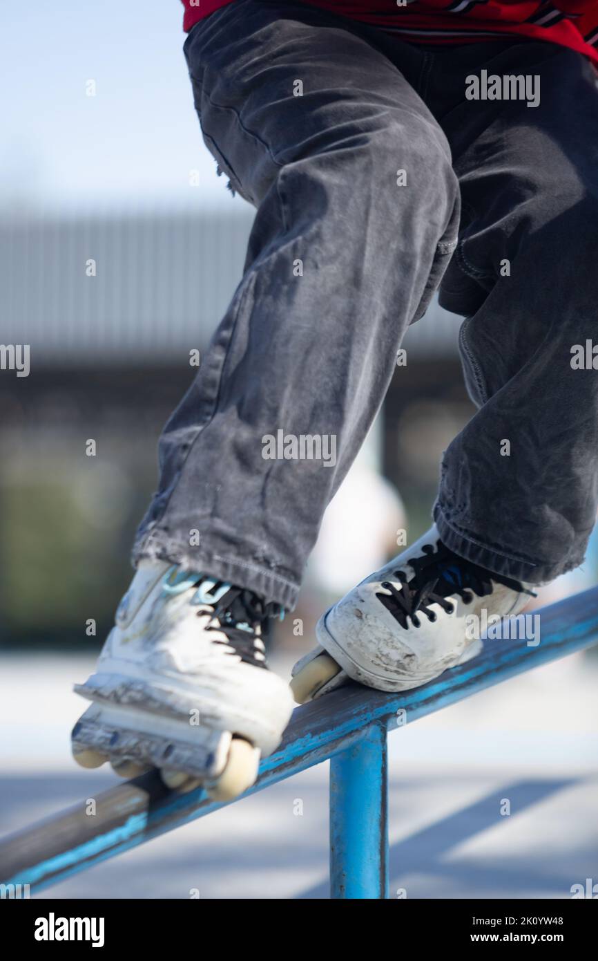 Roller blader grinding on handrail. In line skater grind on rails in