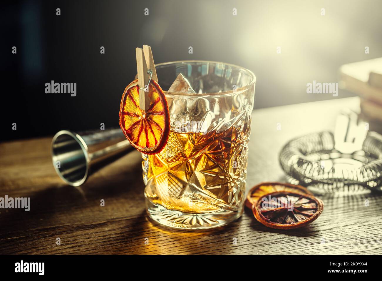 Old fashioned classic cocktail drink in crystal glass on bar counter. Stock Photo