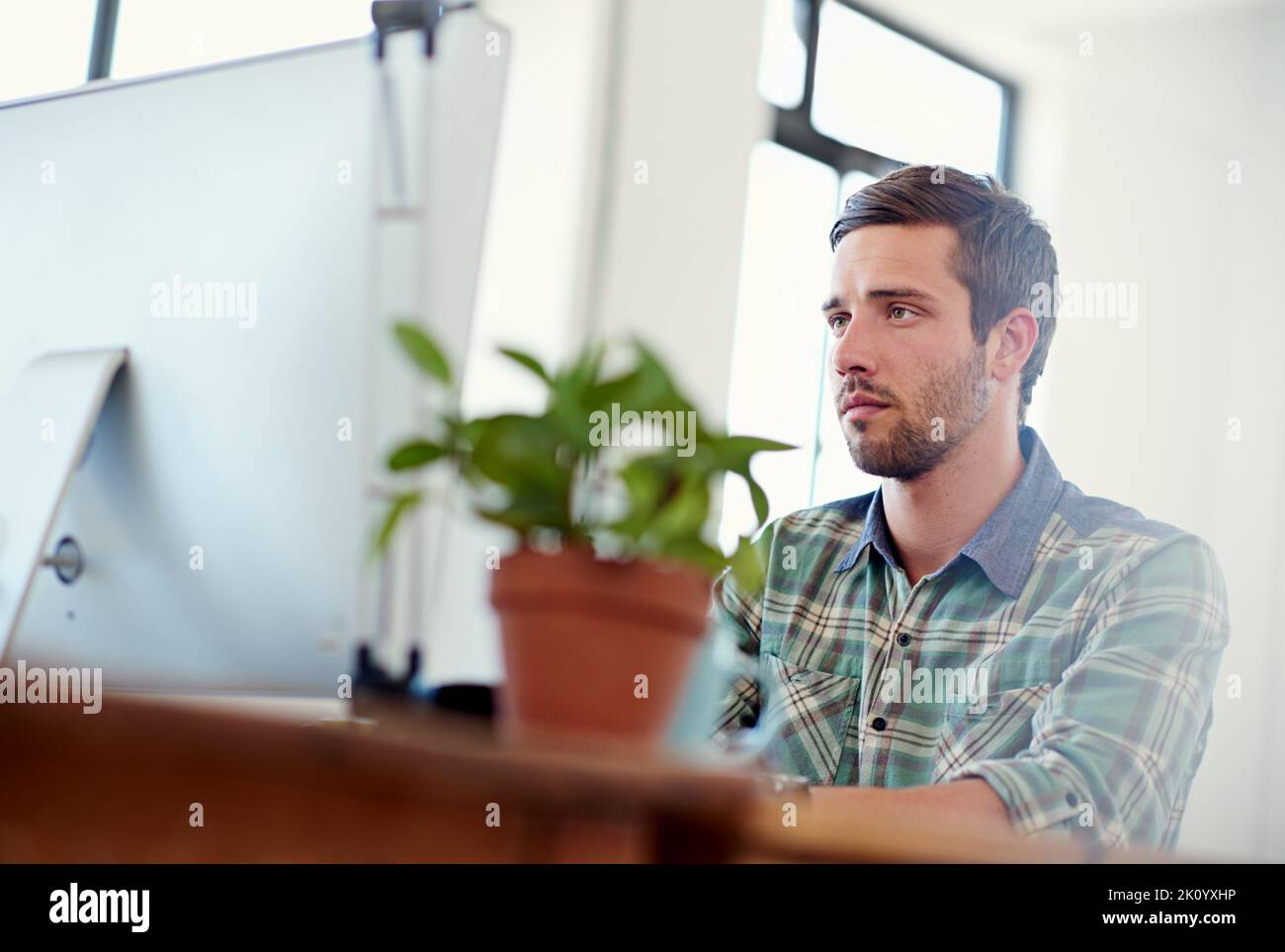 Getting down to business. a casually-dressed young man at work on a computer. Stock Photo