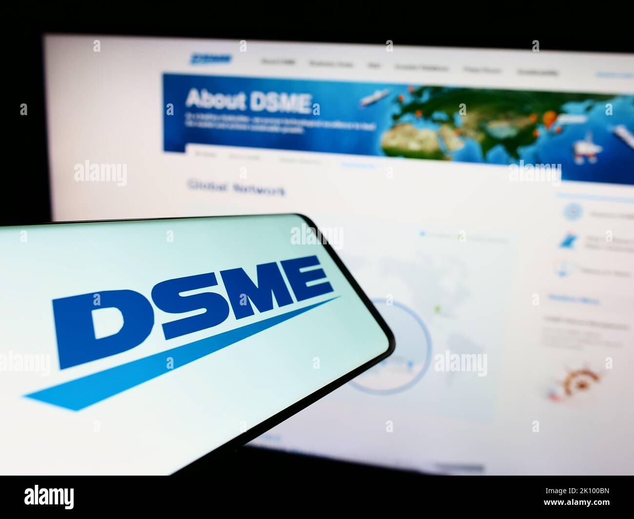 Smartphone with logo of Daewoo Shipbuilding and Marine Engineering (DSME) on screen in front of website. Focus on center-right of phone display. Stock Photo