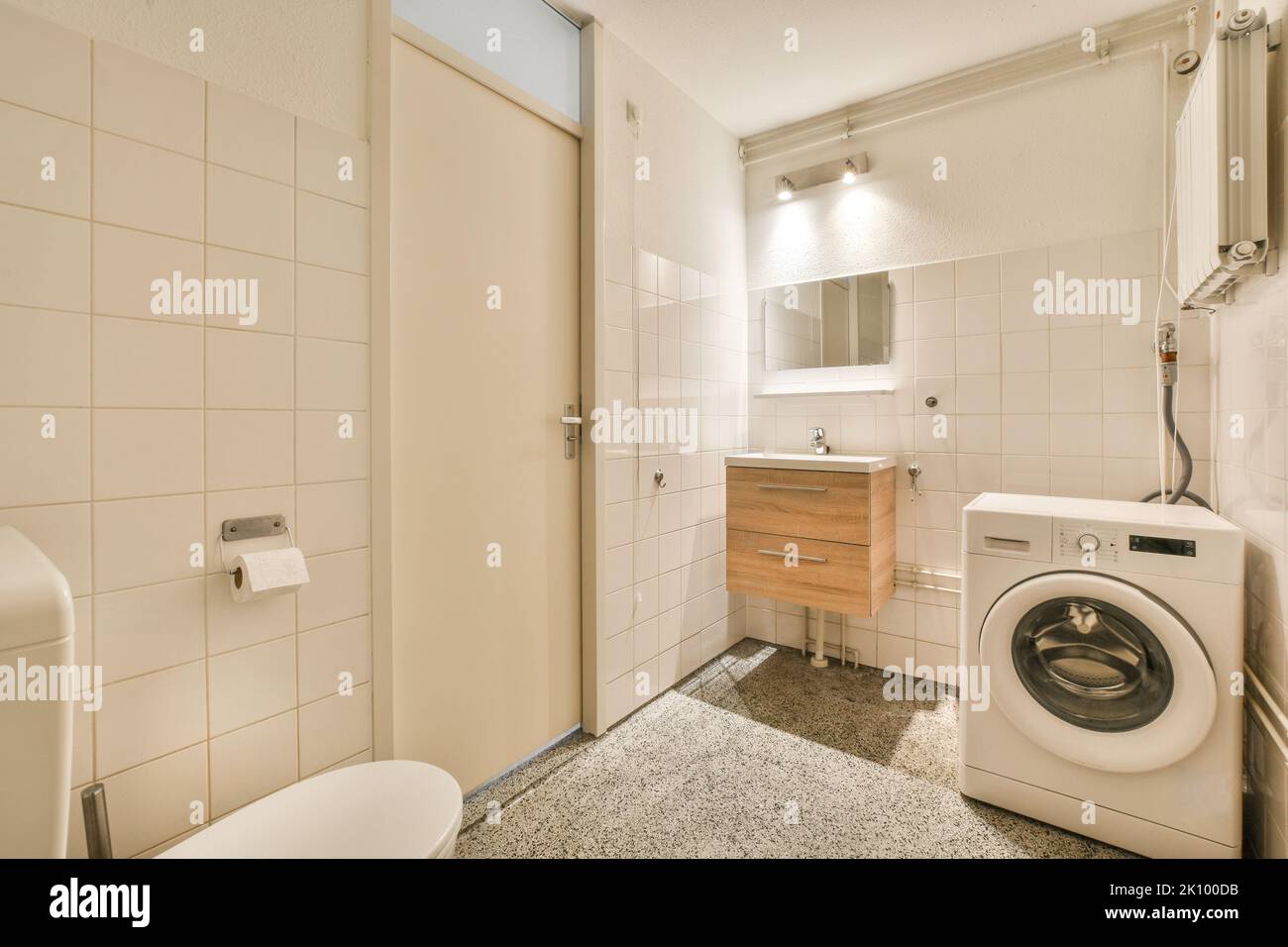 Flush toilet and shower located near sink and washing machine in