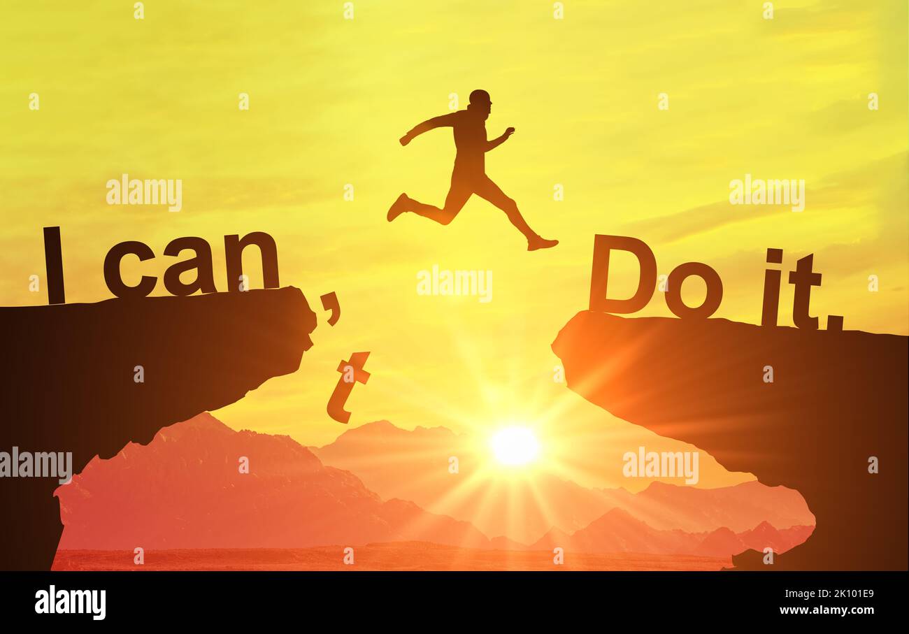 Silhouette man jumping over cliffs for I can do it , good mindset by never give up concept. Motivational image, nothing is impossible. I can do it con Stock Photo