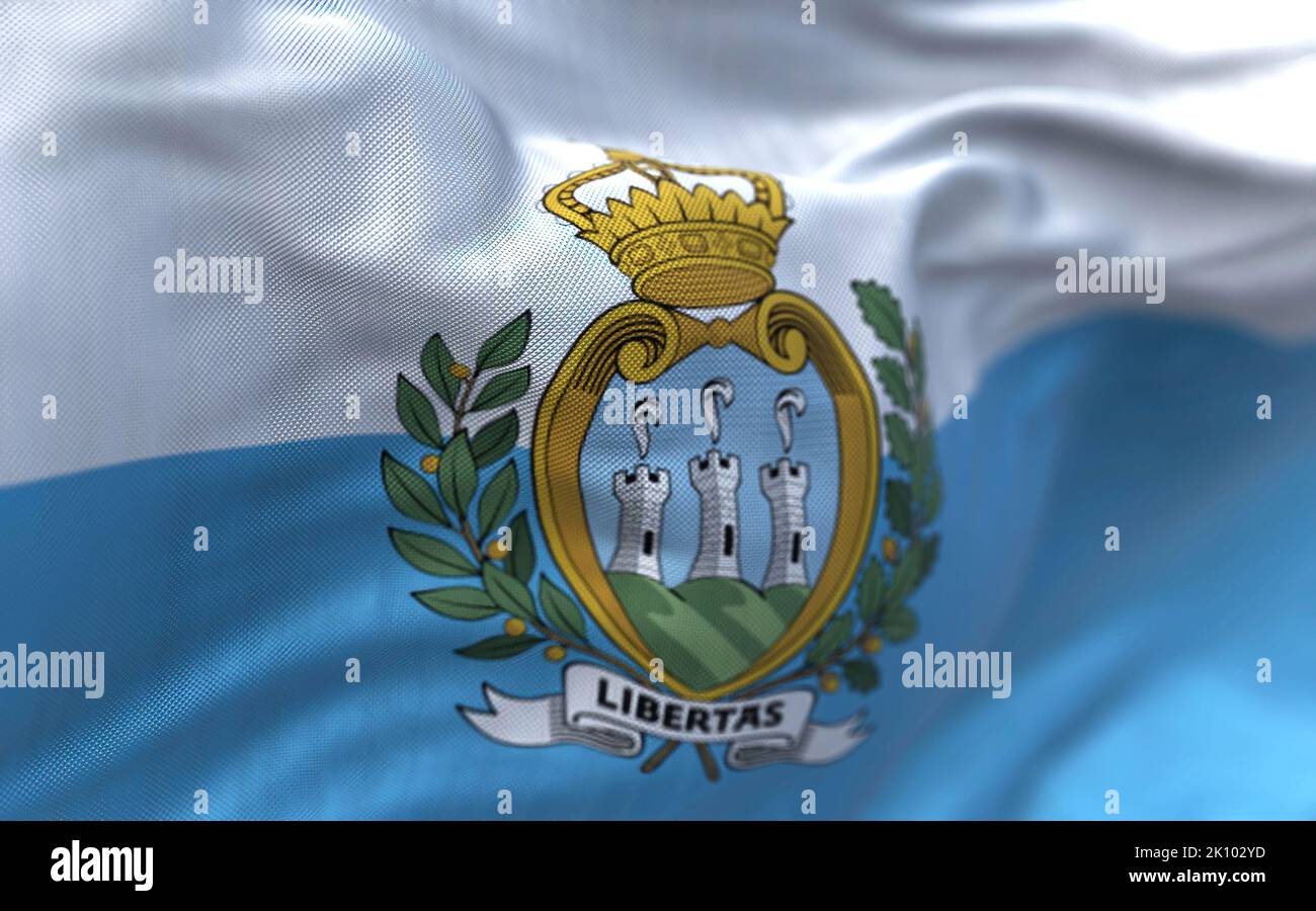 Close-up view of the San Marino national flag waving in the wind. San Marino is a small country in Southern Europe enclaved by Italy. Fabric textured Stock Photo