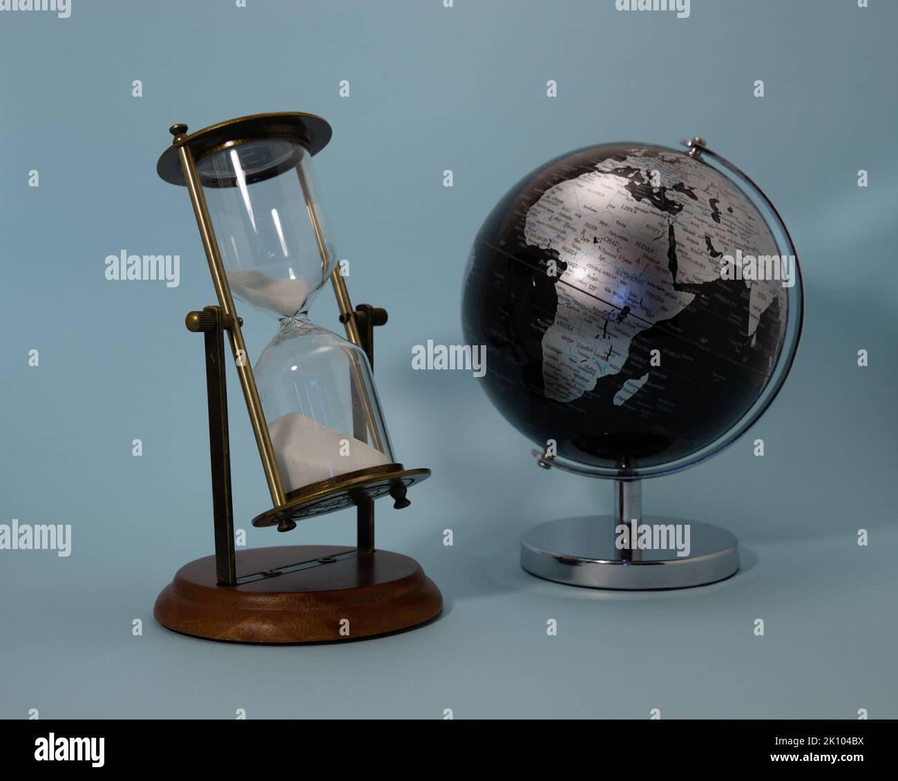 retro hourglass composition with black globe on celestial background Stock Photo