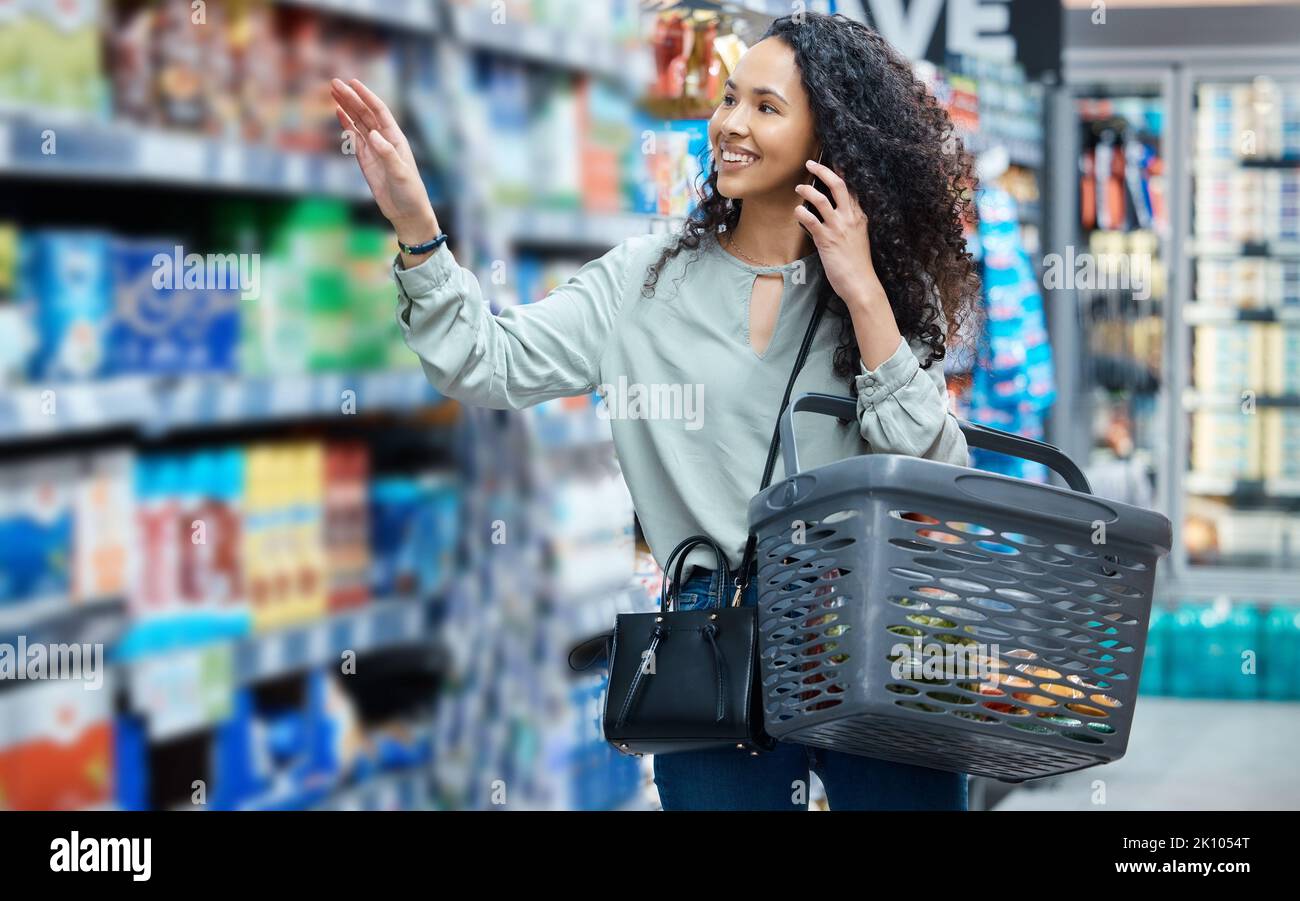 Happy supermarket, grocery shopping and with phone call, smile and in retail store for food, groceries or product from shelf. Woman customer with 5g Stock Photo