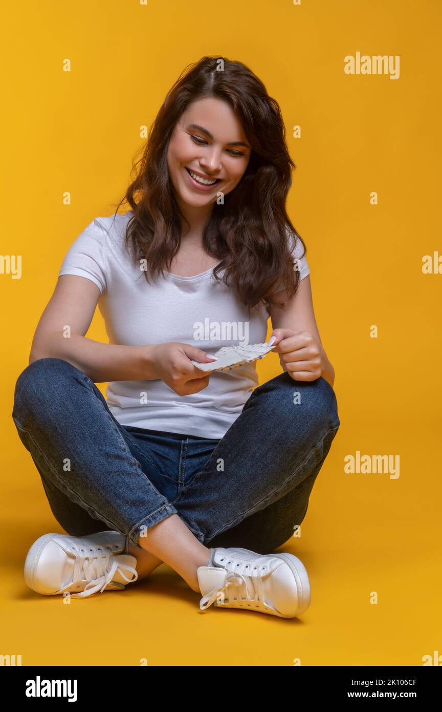 Woman sitting crosslegged on floor with letter Stock Photo Alamy