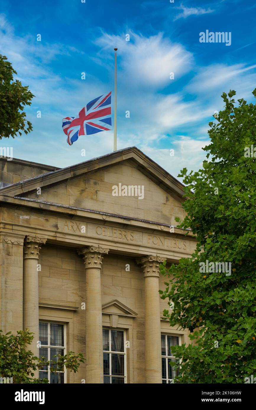 The Union Jack blowing in the wind was flying half-mast above Harrogate Borough Council's former headquarters, Crescent Gardens, Harrogate, UK. Stock Photo