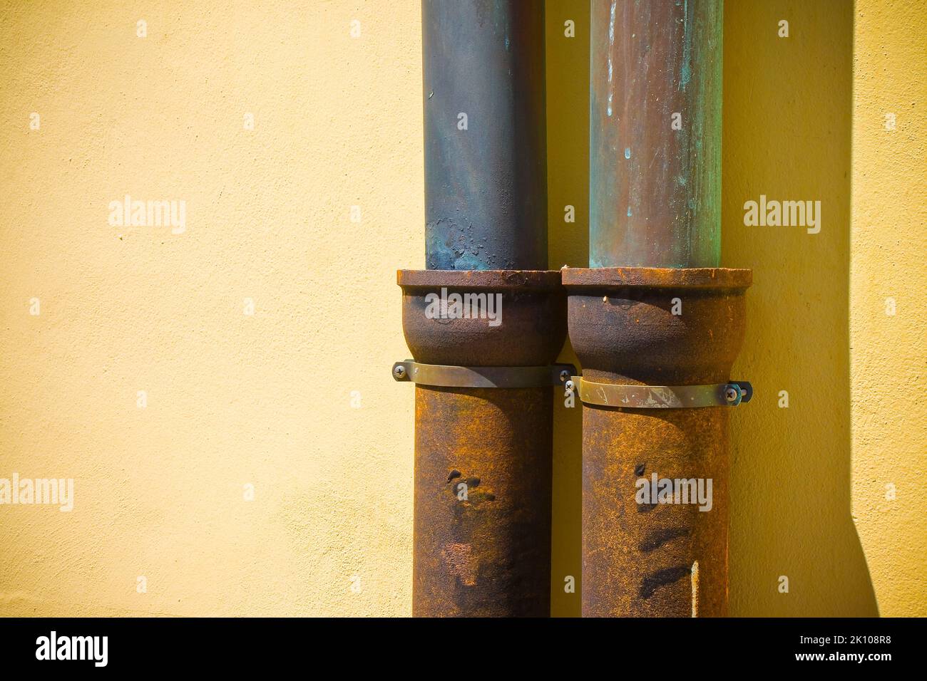 Detail of pair of downpipes copper and cast iron on a colorful facade Stock Photo