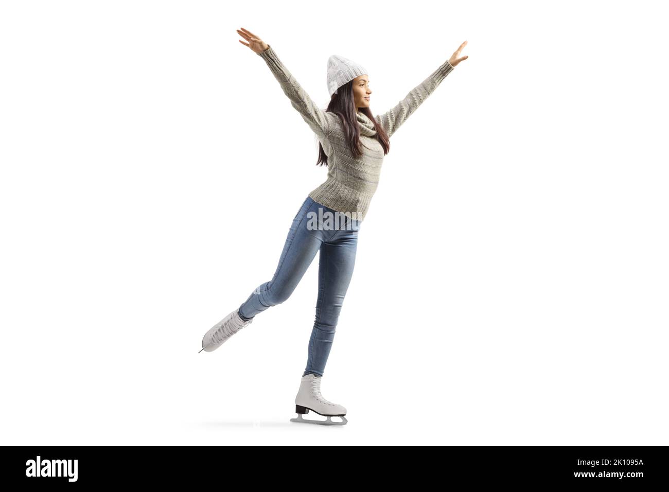 Full length shot of a young casual female ice skating isolated on white background Stock Photo