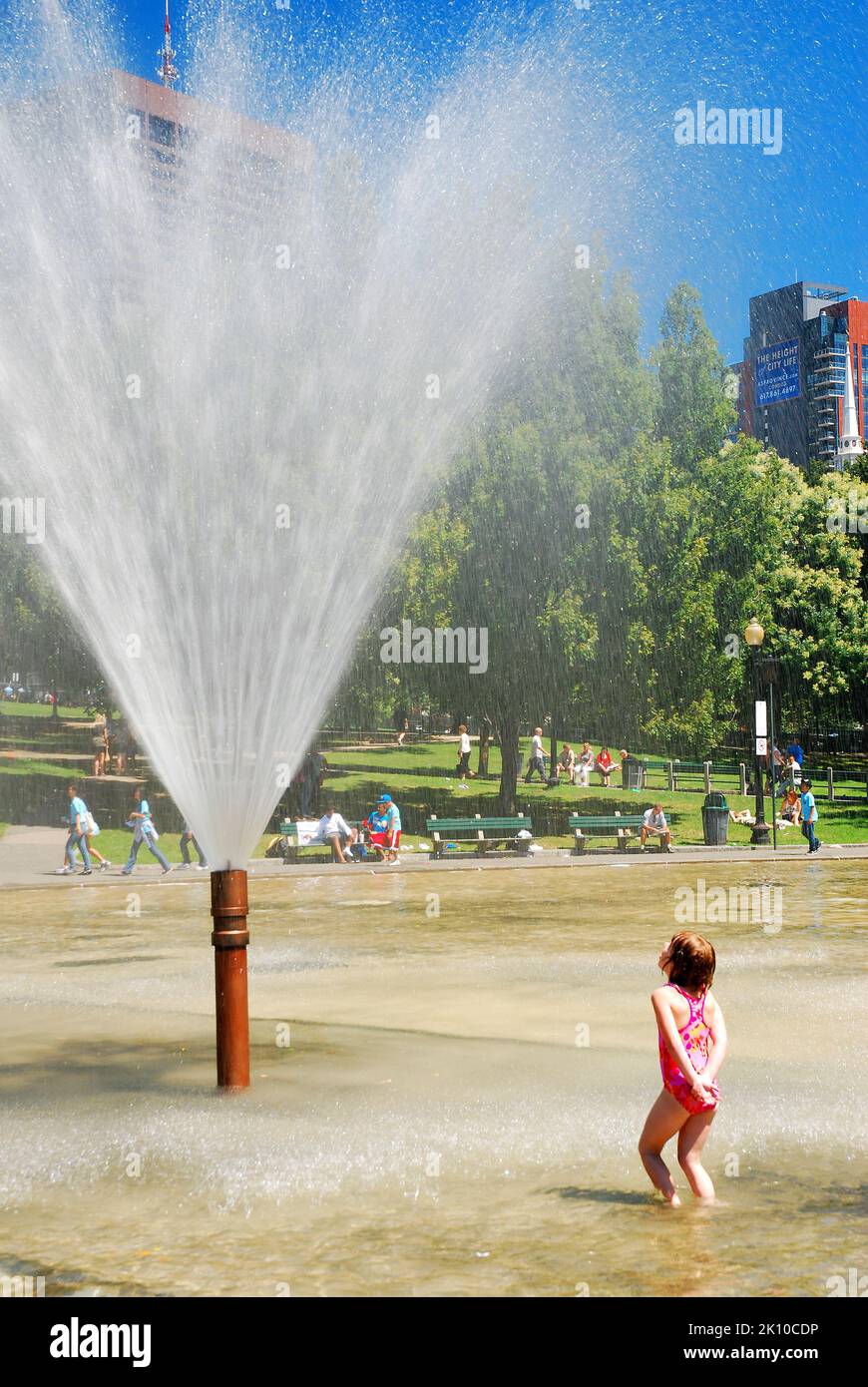 A Child Cools off on a hot summer's day at the water fountain in the Frog Pond in Boston Common Stock Photo