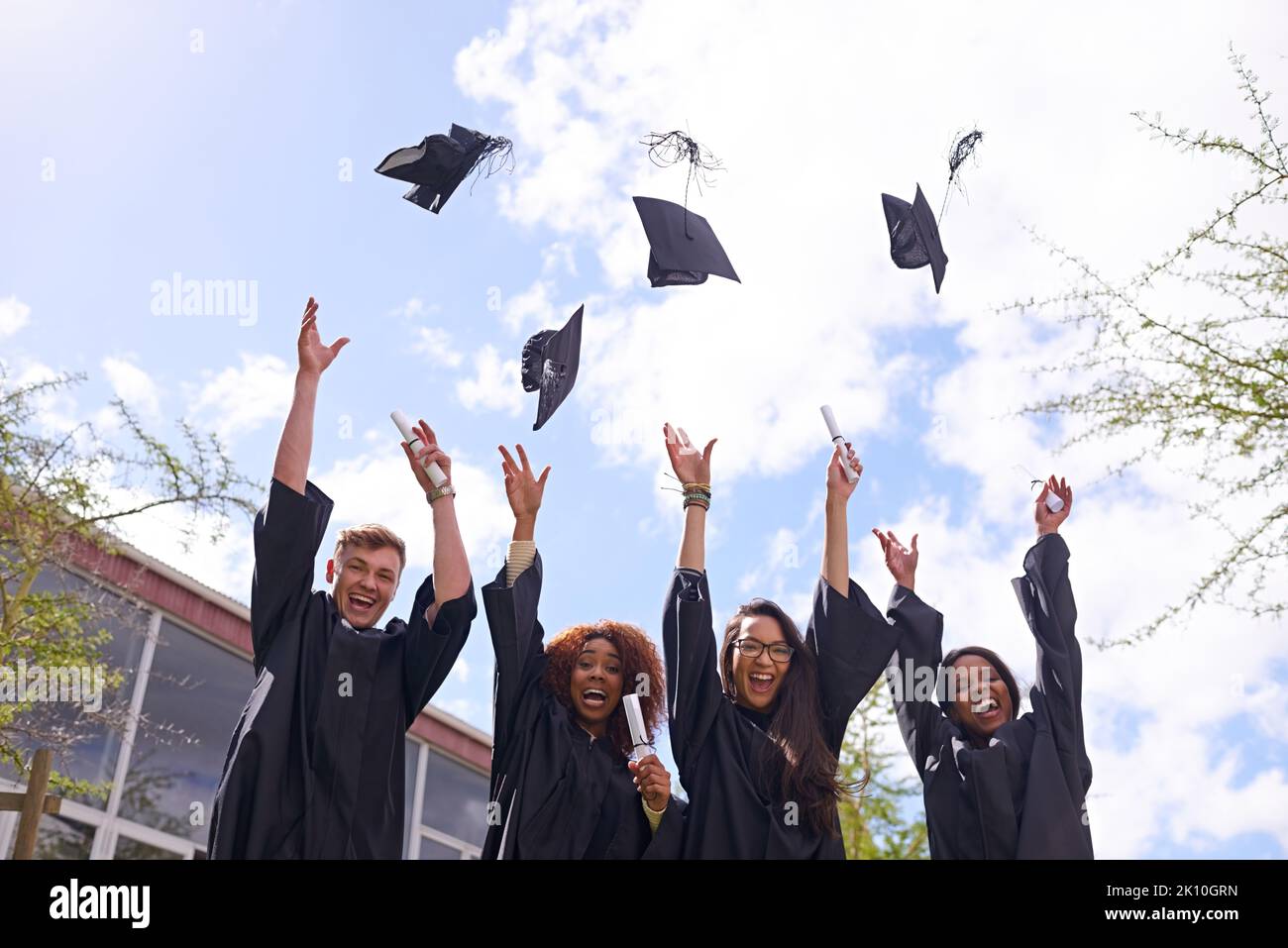 Reason to celebrate. Low angle shot of student throwing their