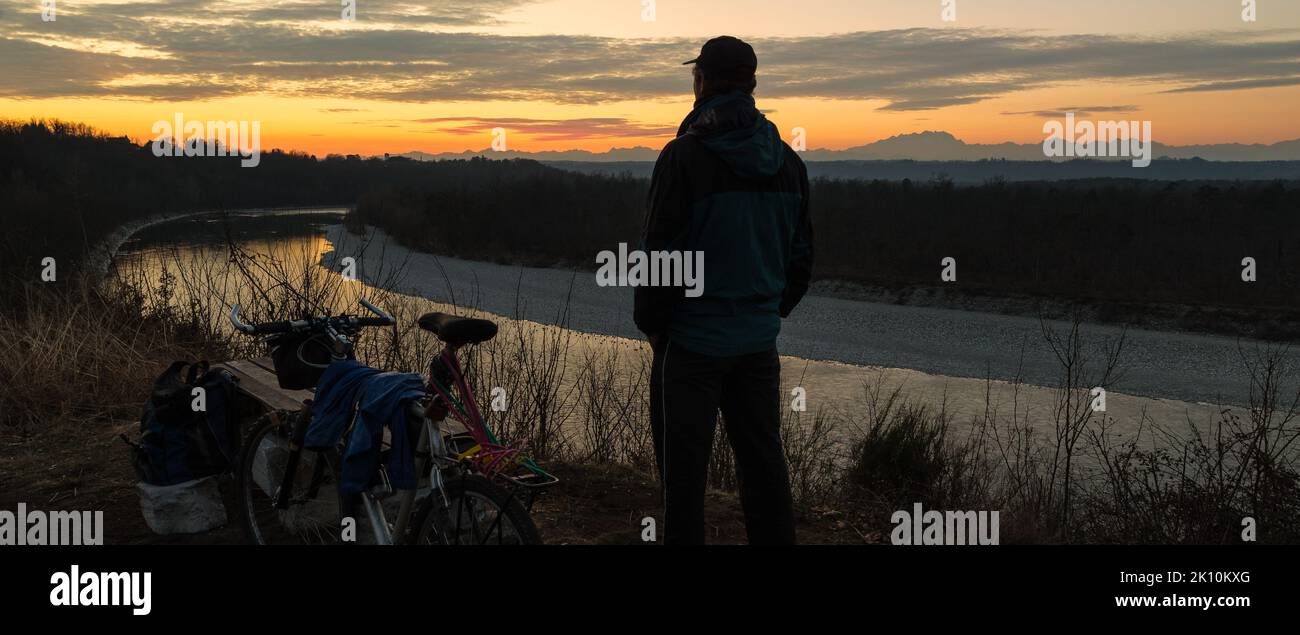 Man with mountain bike at sunset. Concept of adventure, freedom and outdoor recreation. Ticino Park and river Ticino Stock Photo