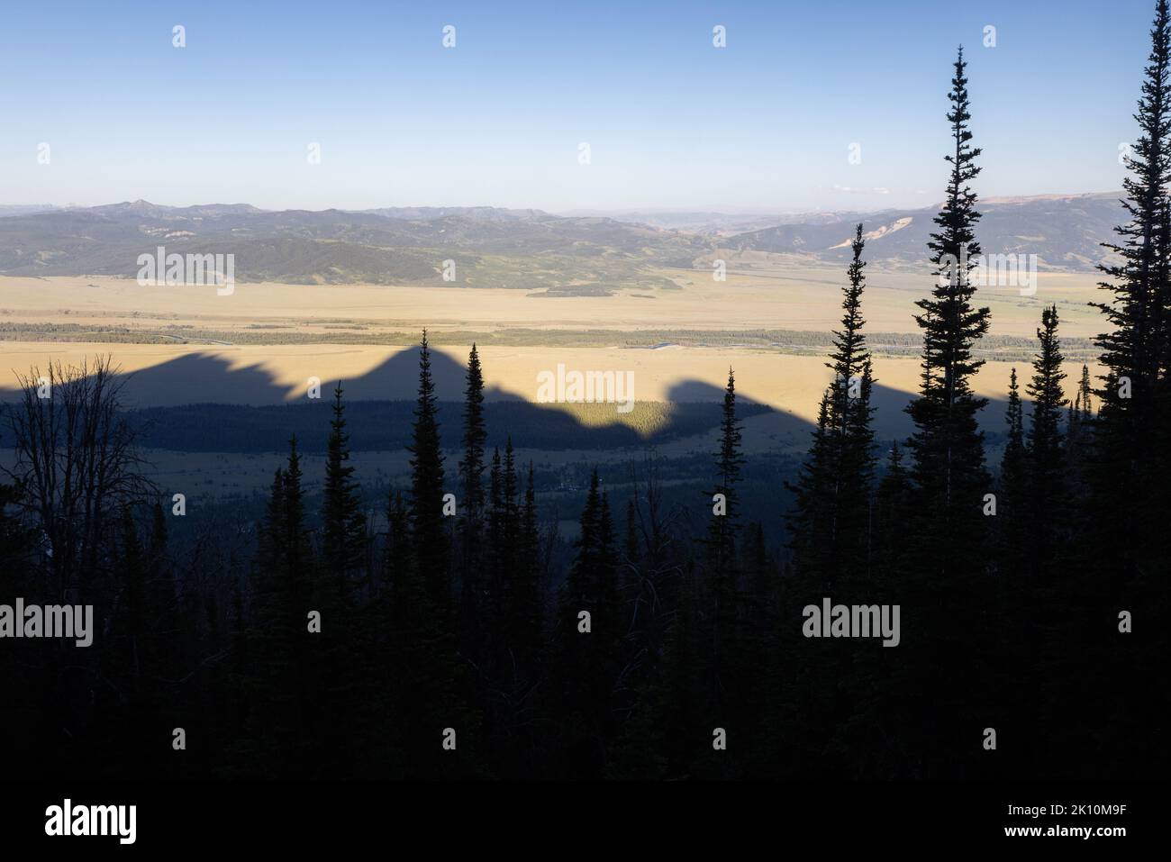 The shadows of the core Teton Mountain peaks extending over the valley ...
