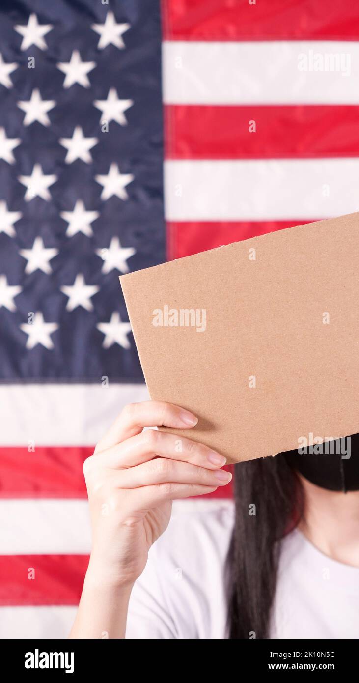 Unrecognizable woman showing empty cardboard banner. Hands holding blank poster from a cardboard box. Space for your slogan, logo or advertisement. Ba Stock Photo