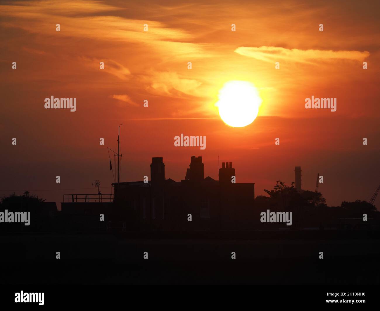 Sheerness, Kent, UK. 14th Sep, 2022. UK Weather: sunset at the end of a day of fine weather in Sheerness, Kent. A flag seen at half mast to mourn HM Queen Elizabeth II. Credit: James Bell/Alamy Live News Stock Photo