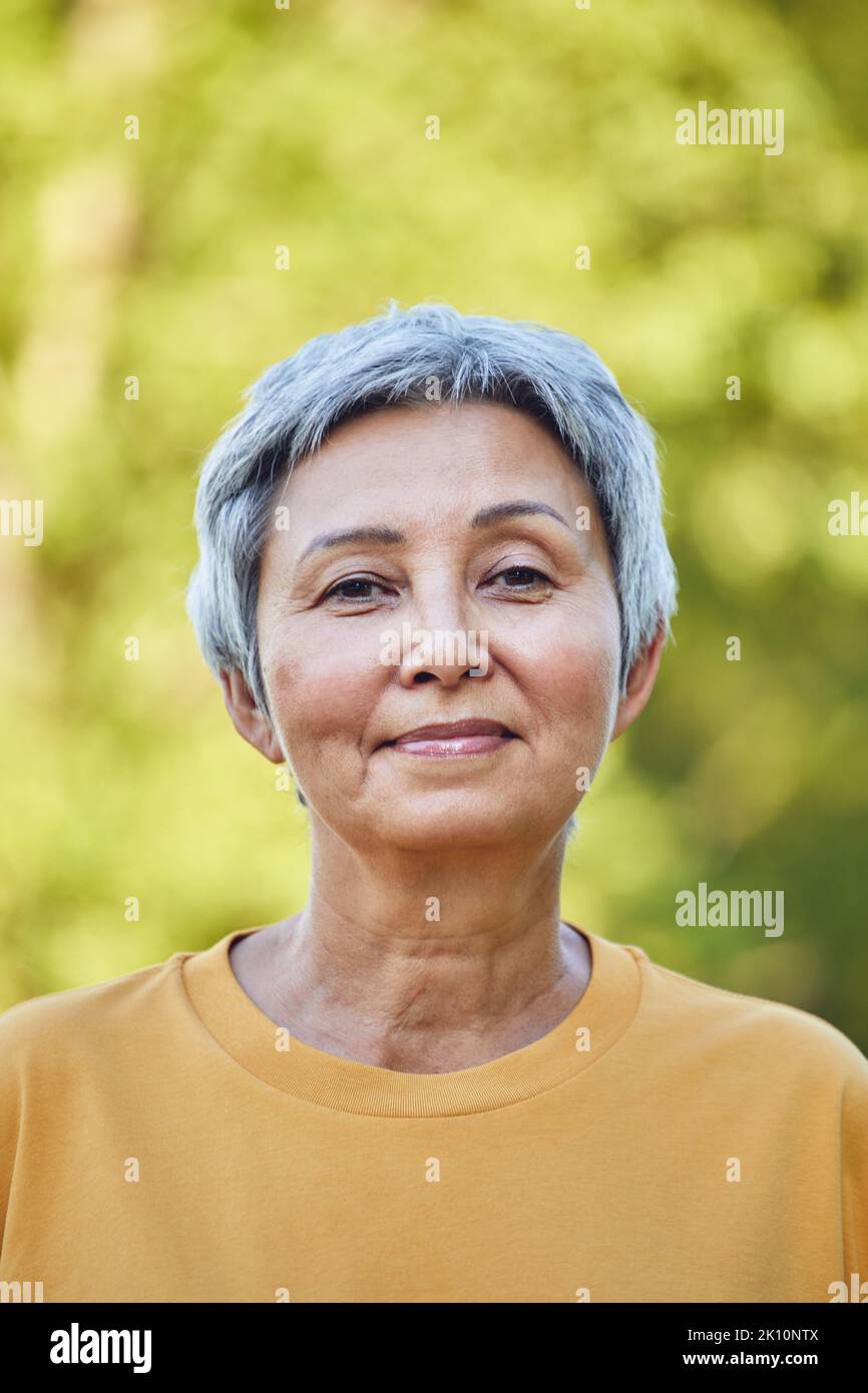 Headshot portrait pretty older grey haired retired woman with short