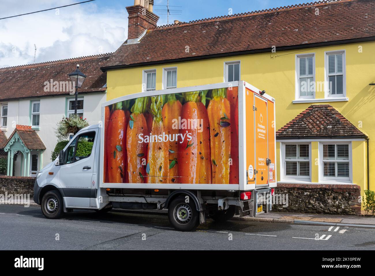 Sainsburys supermarket delivery van outside a yellow house, England, UK, home delivery vehicle Stock Photo