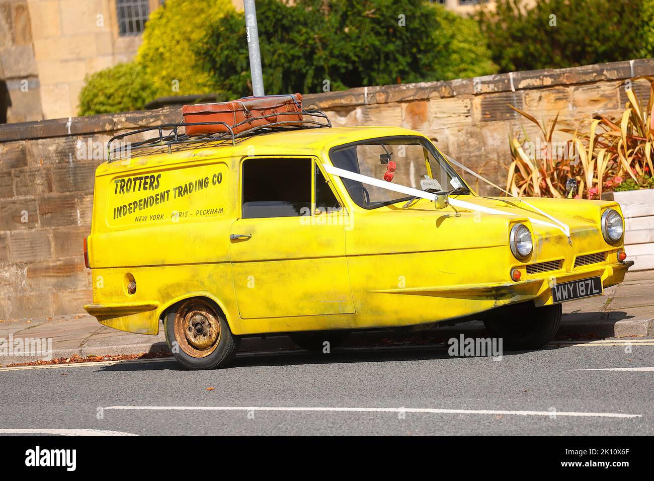 A replica of Trotters yellow Reliant Robin from the TV sitcom 'Only Fools & Horses' seen used as a wedding car in Swillington,Leeds,UK Stock Photo