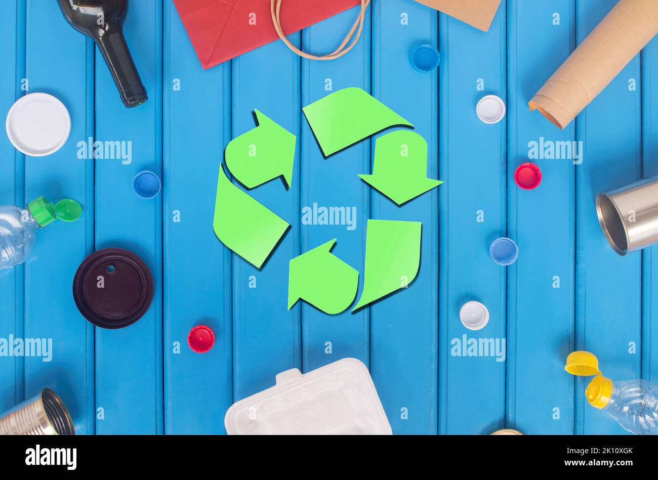 Green recycling icon surrounded by recycled materials into new, full