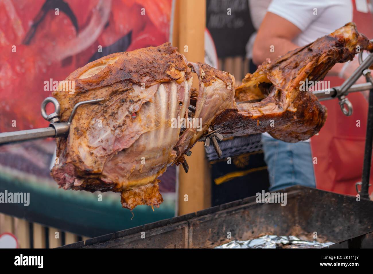 Process of cooking pork on spit at summer street food market Stock Photo