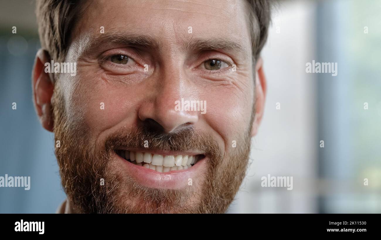 Front view close up male portrait indoors serious pensive dreaming planning man looking away thinking turn head to camera smiling toothy dental happy Stock Photo
