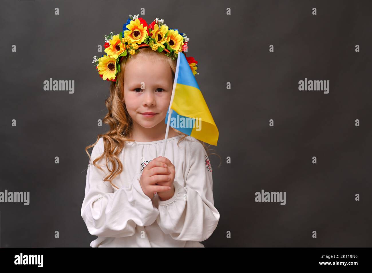 A girl with a beautiful wreath and the flag of Ukraine on a gray background. mock up Stock Photo