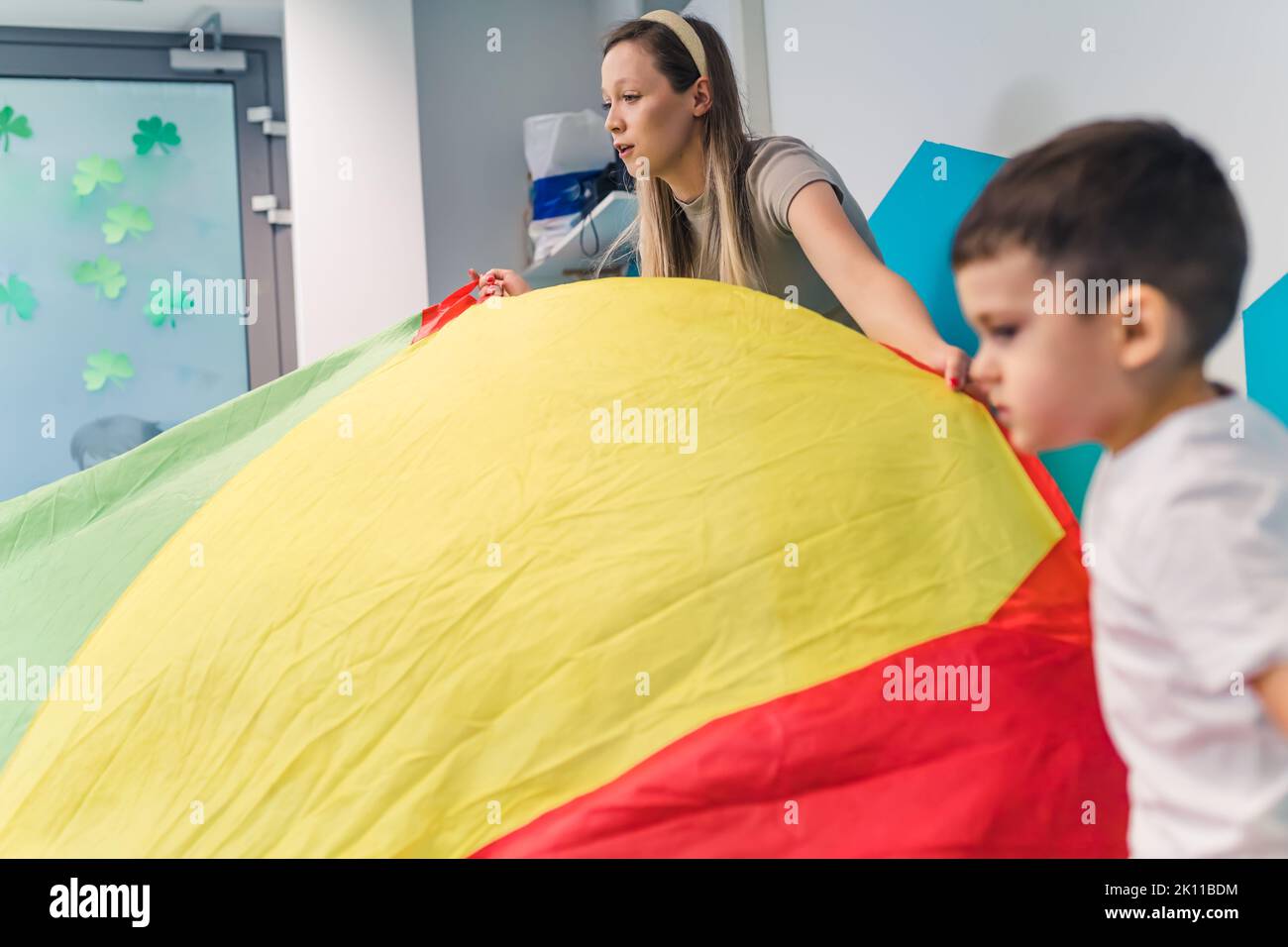 Happy toddler and his teacher engaged in an active sensory play with colors at the nursery school. Early development. Healthy brain. High quality photo Stock Photo