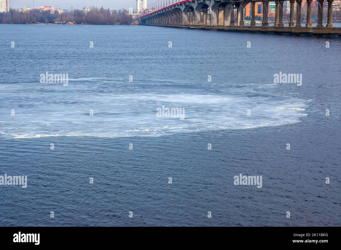 Thin ice floe drifts downstream in springtime Stock Photo