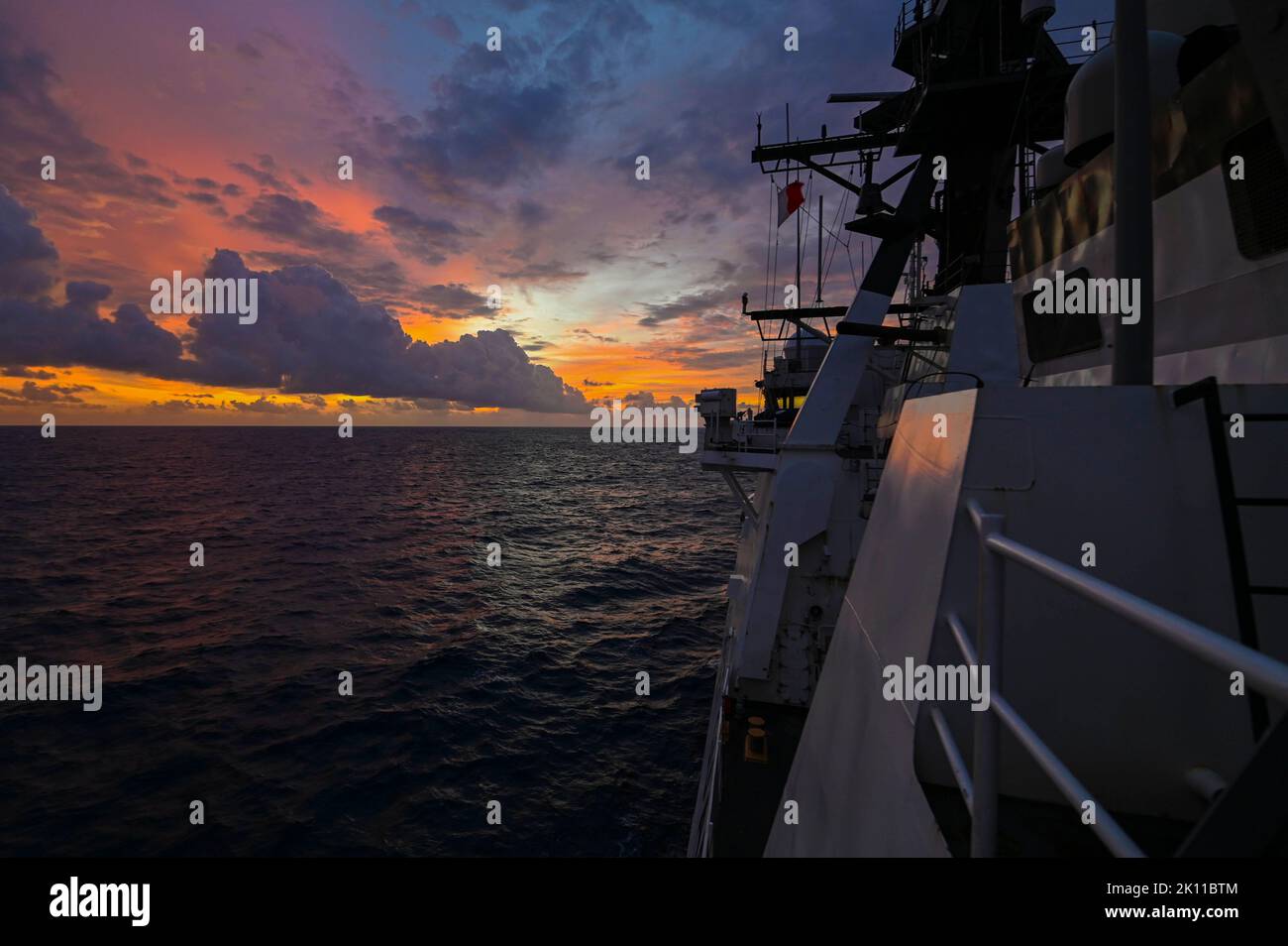 U.S. Coast Guard Cutter Midgett (WMSL 757) transits the Indian Ocean around sunset on Sep. 13, 2022. The crew of the cutter are under the tactical control of Commander, U.S. 7th Fleet. (U.S. Coast Guard photo by Petty Officer Steve Strohmaier) Stock Photo