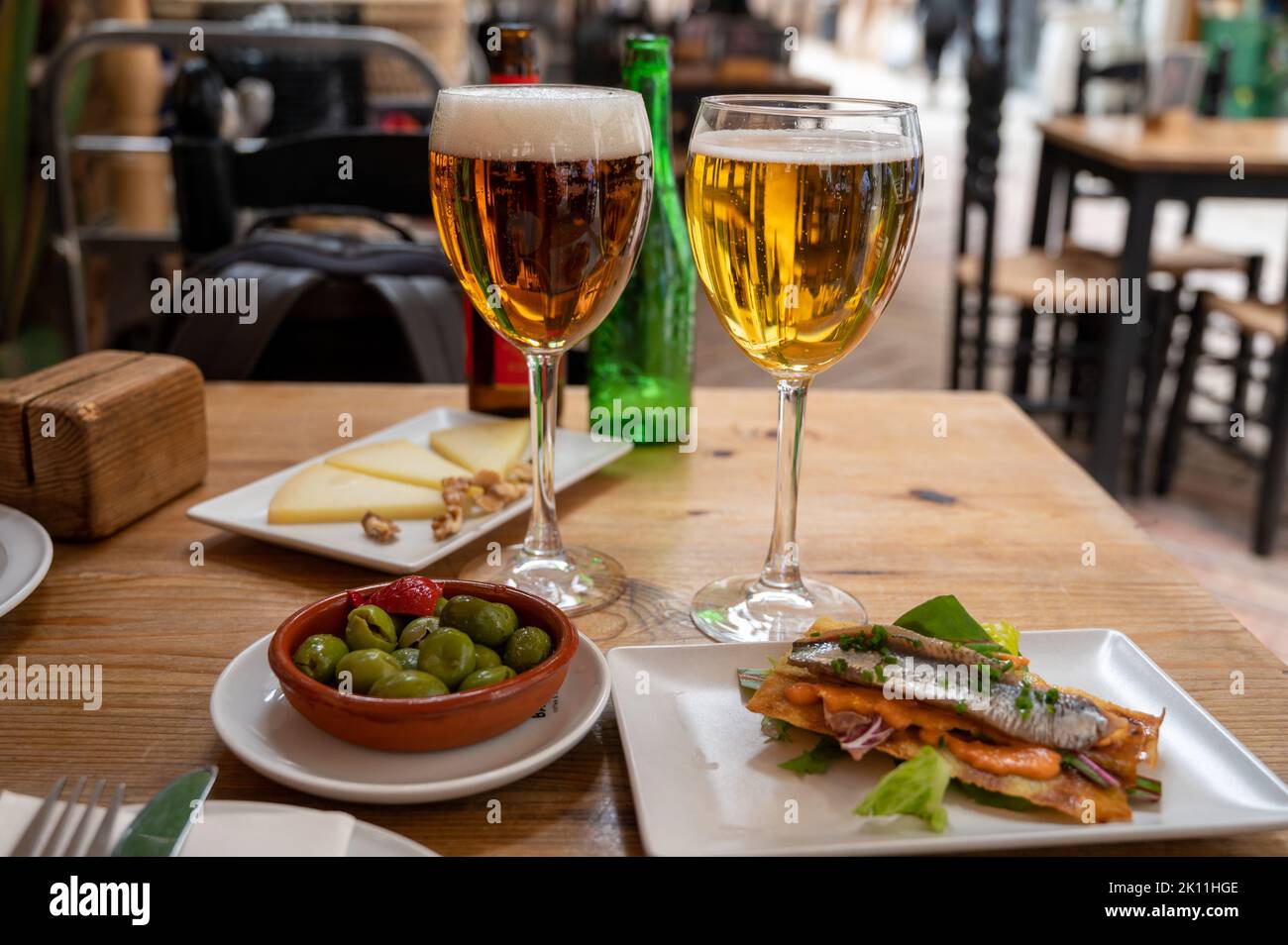 Lunch with cold beer in Spanish outdoor cafe, different tapas, green
