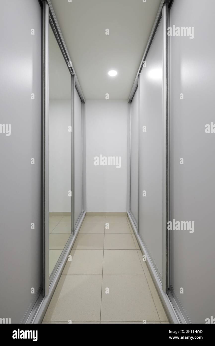 Sliding wardrobe with a mirror Stock Photo - Alamy