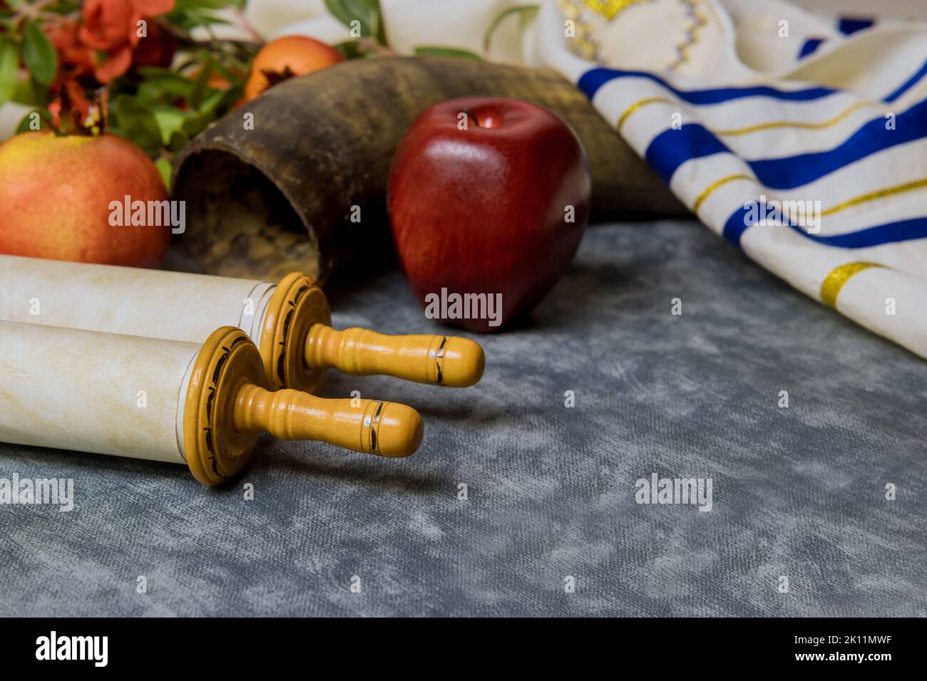 The Orthodox New Year symbols of Rosh Hashanah display a bowl of honey, a shofar, apples, and pomegranates Stock Photo