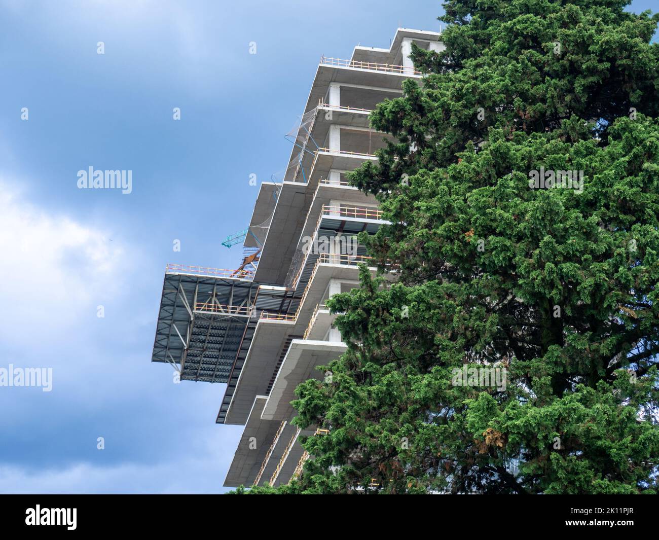 Part of the construction of a tall building. House and nature. House ...