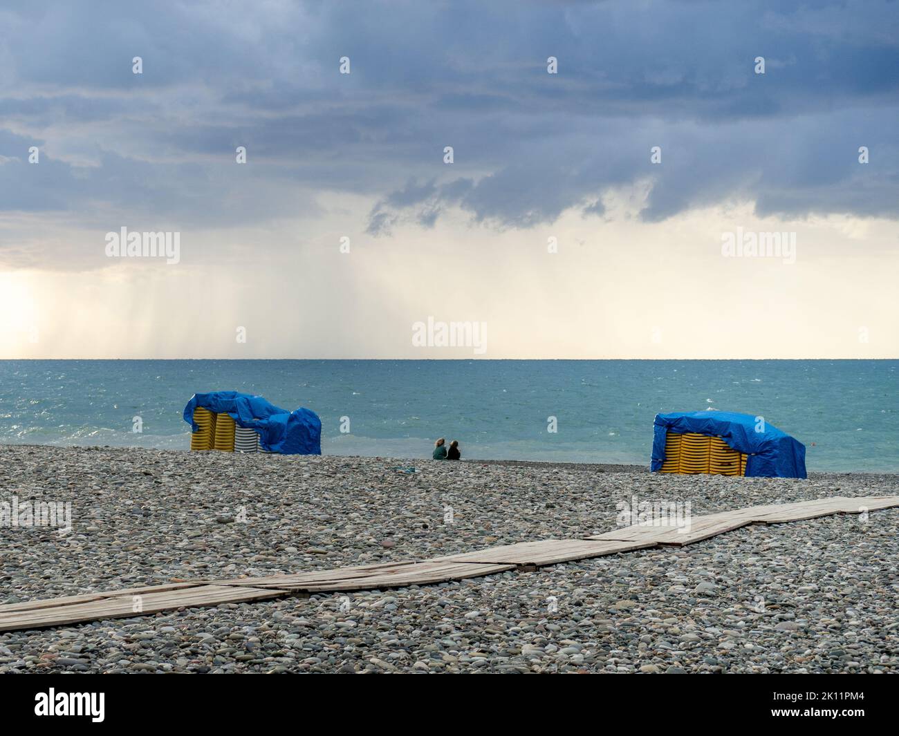 Sunbeds on the beach are placed one on top of the other. Bad weather sea. A big wave. Bathing is