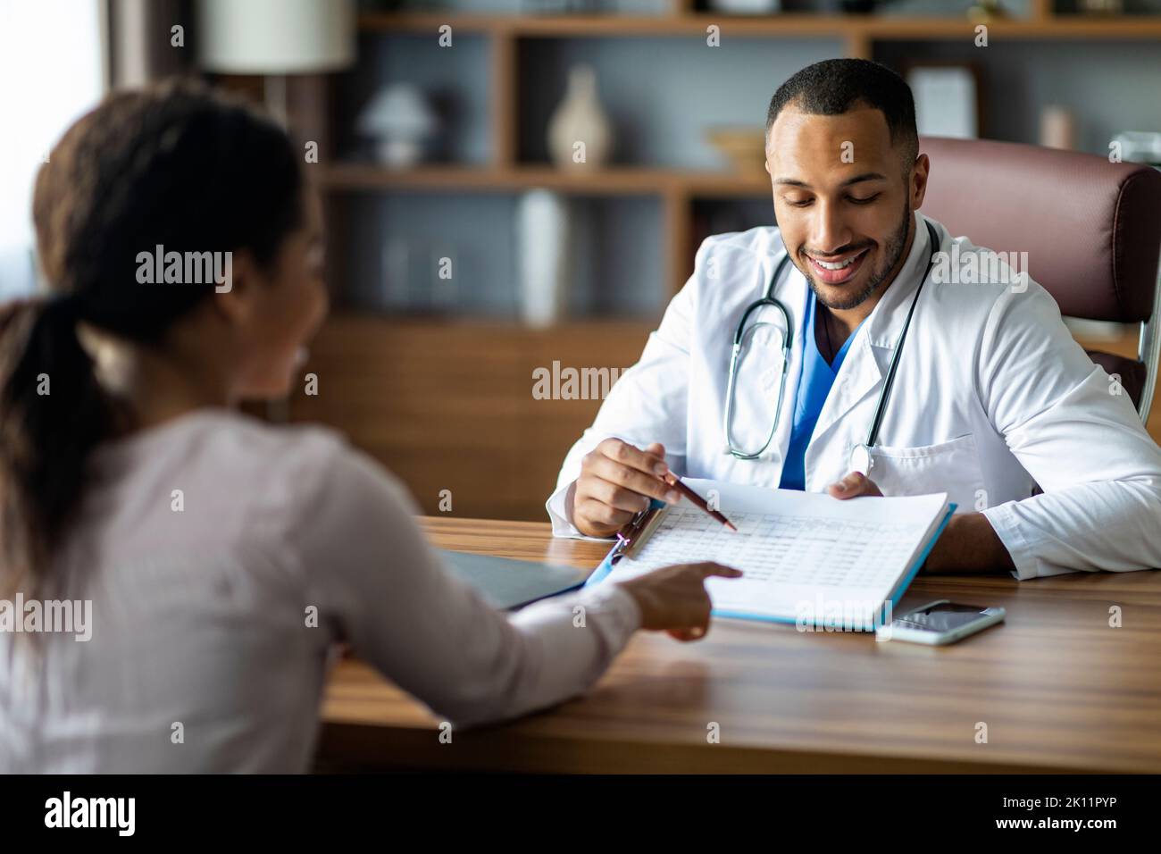 Handsome african american doctor showing patient treatment plan Stock Photo