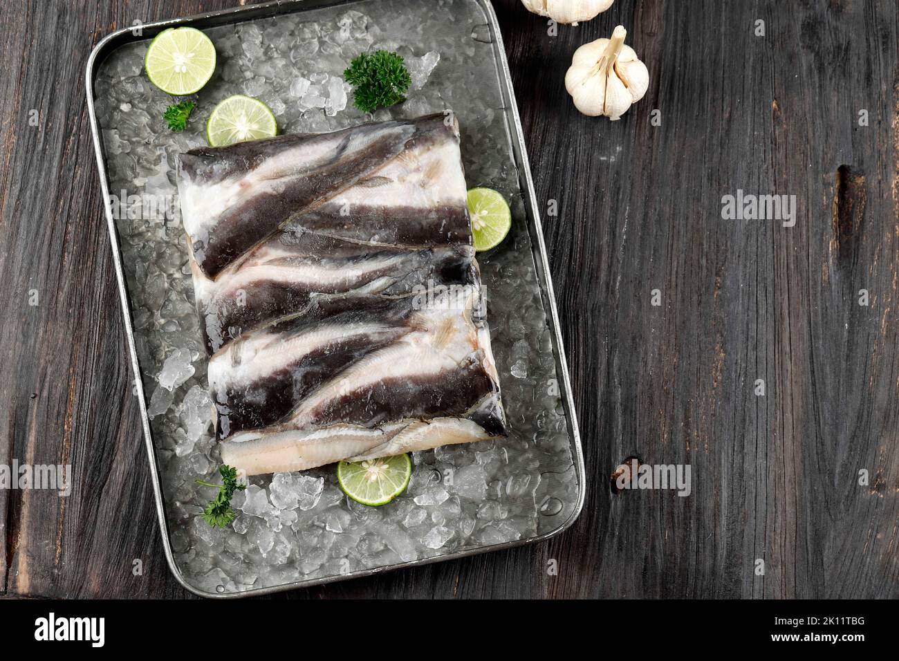 Raw Catfish FIllet with Skin, Top View on Wooden Background. Copy Space
