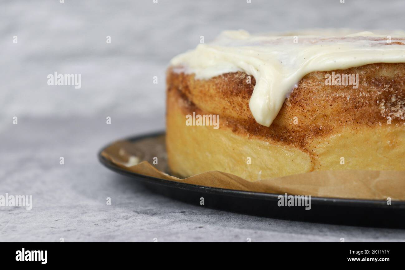 close up of buttercream frosting on cinnamon roll cake, white