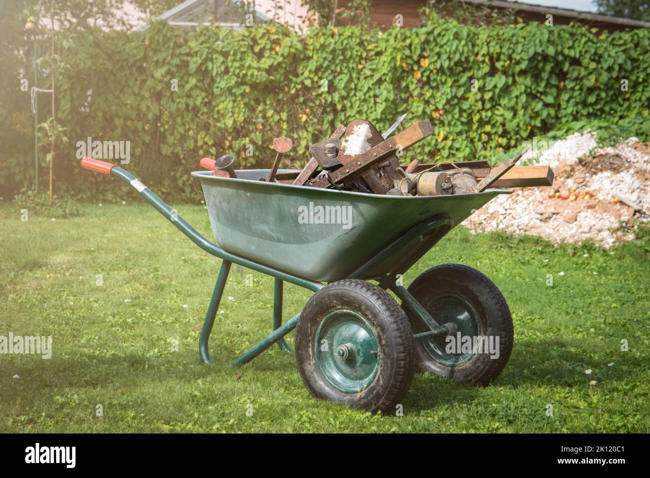 Pile of scrap metal in a barrow. Yard and garden cleaning. Stock Photo