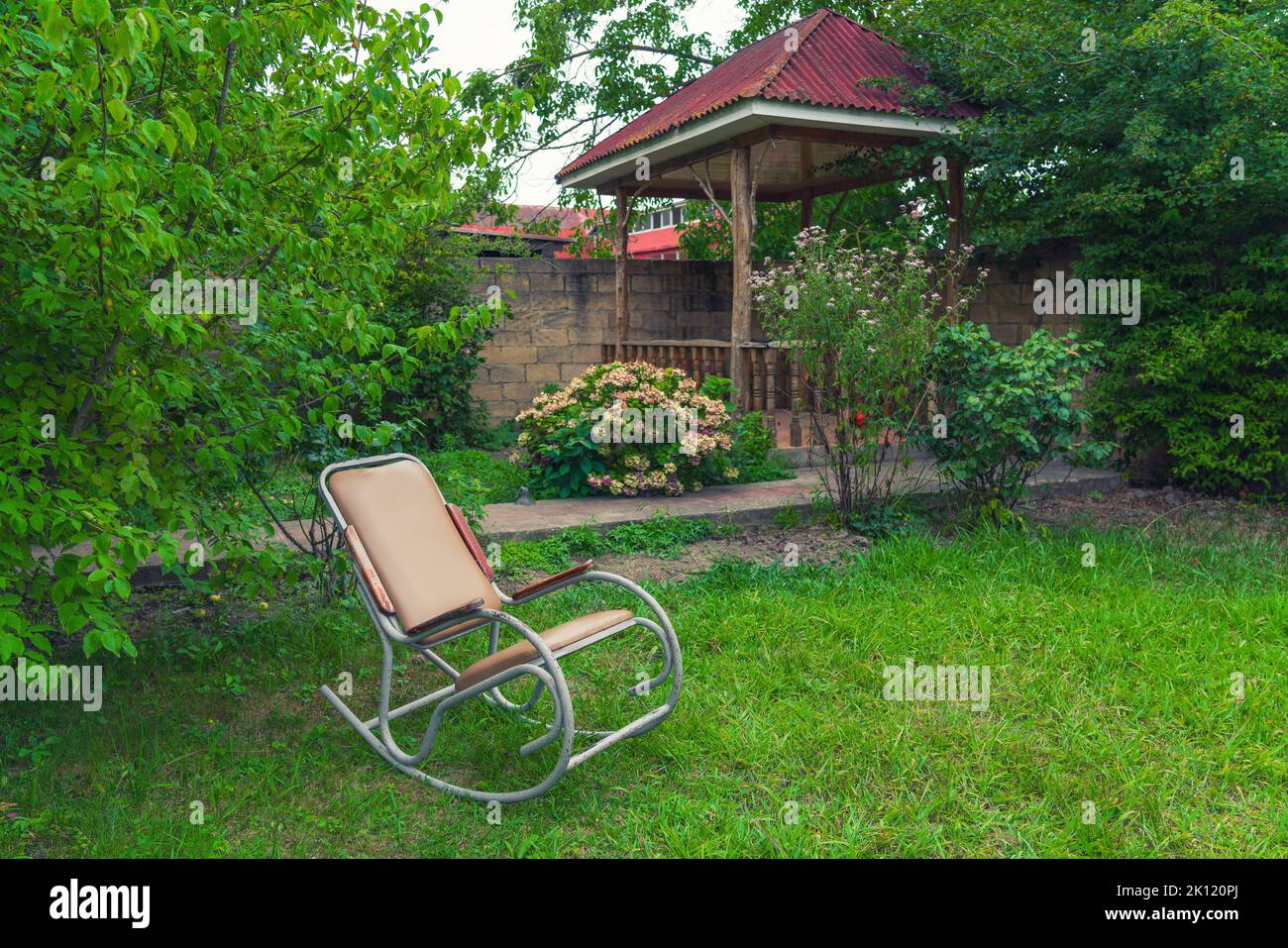 Rocking chair in the garden of a country house Stock Photo