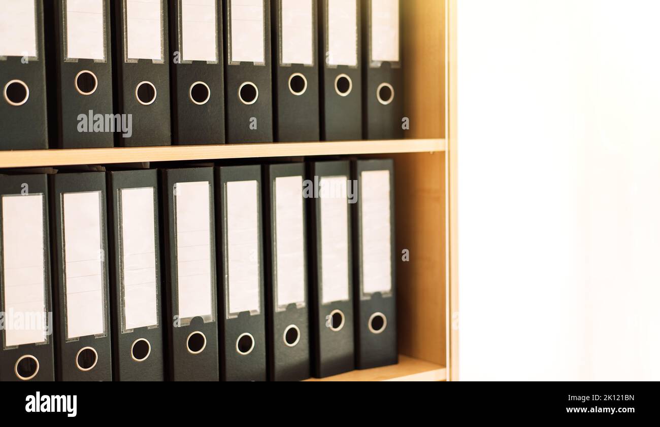 Black office folders standing on cabinet shelves Stock Photo