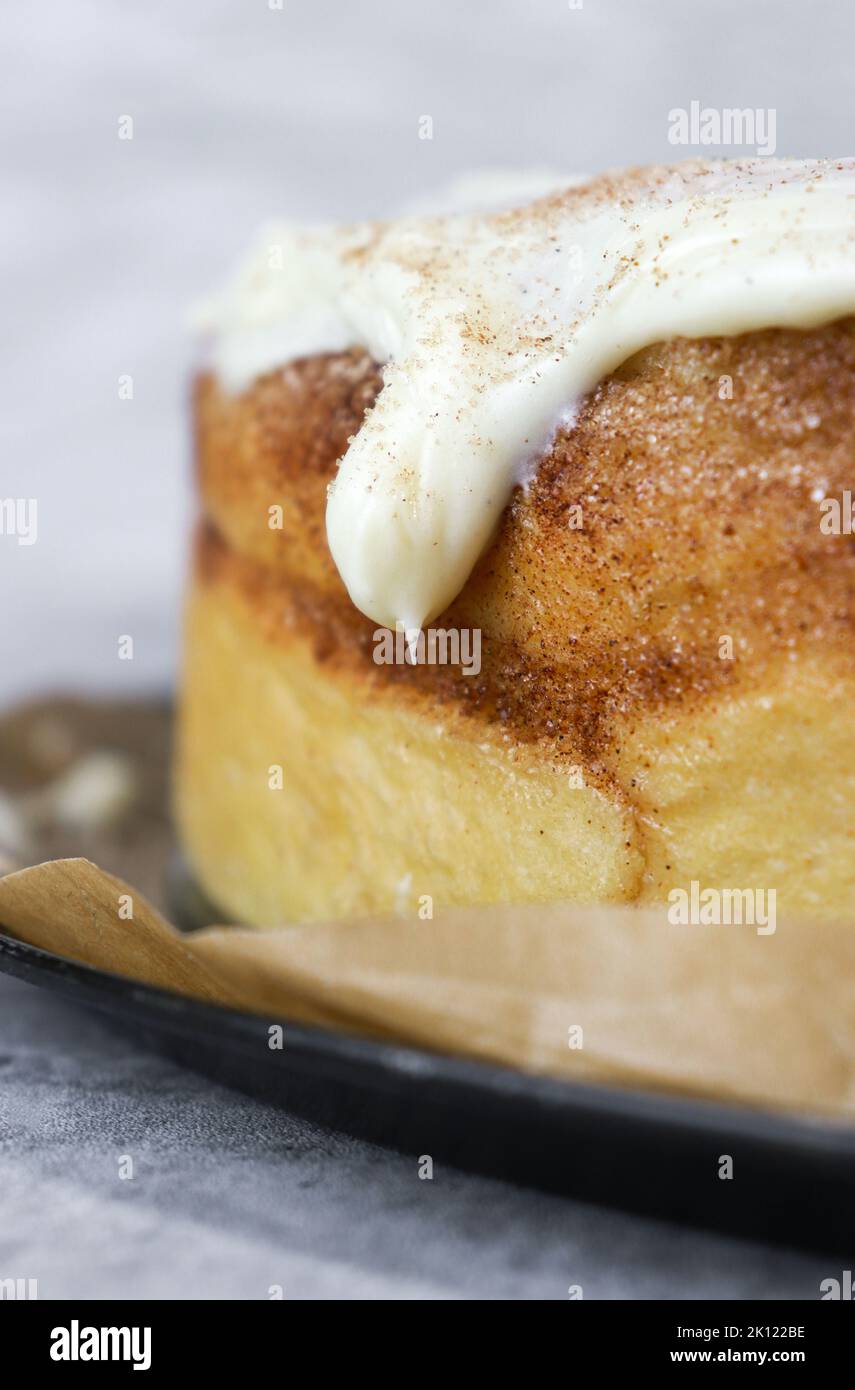 close up of buttercream frosting on cinnamon roll cake, white