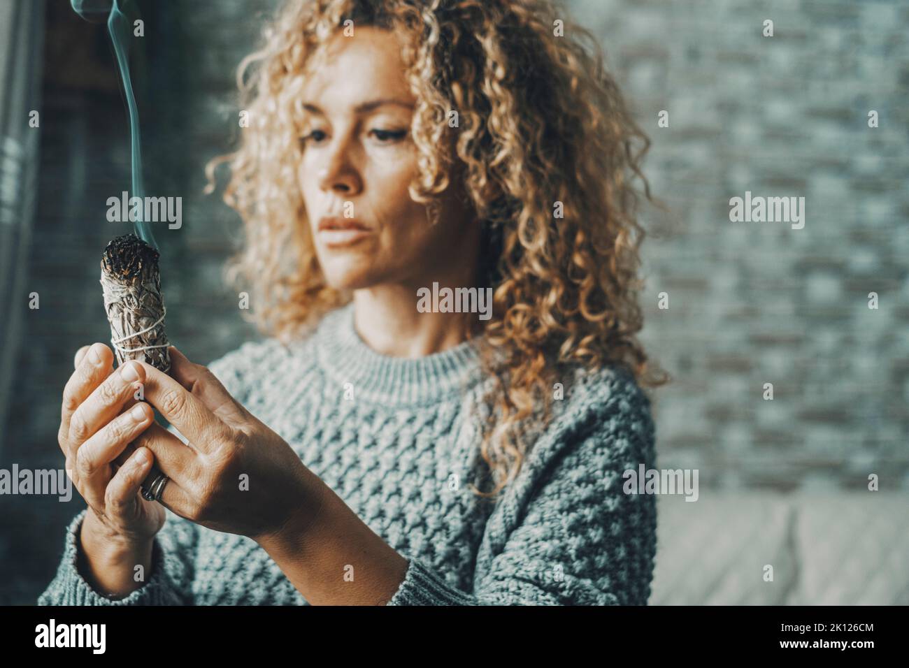 Portrait of a woman using a palo santo herbal incense to purify air and