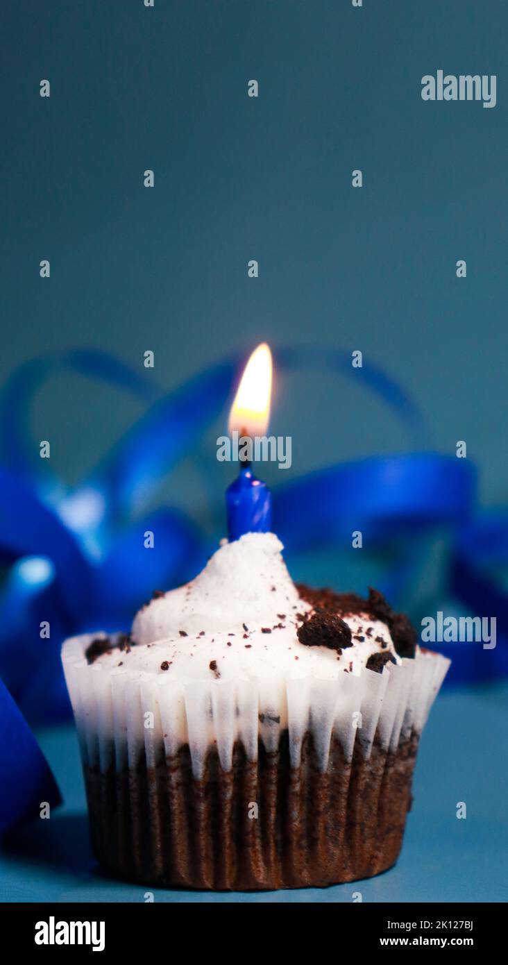chocolate cupcake with a birthday blue candle, blue background and blue ...