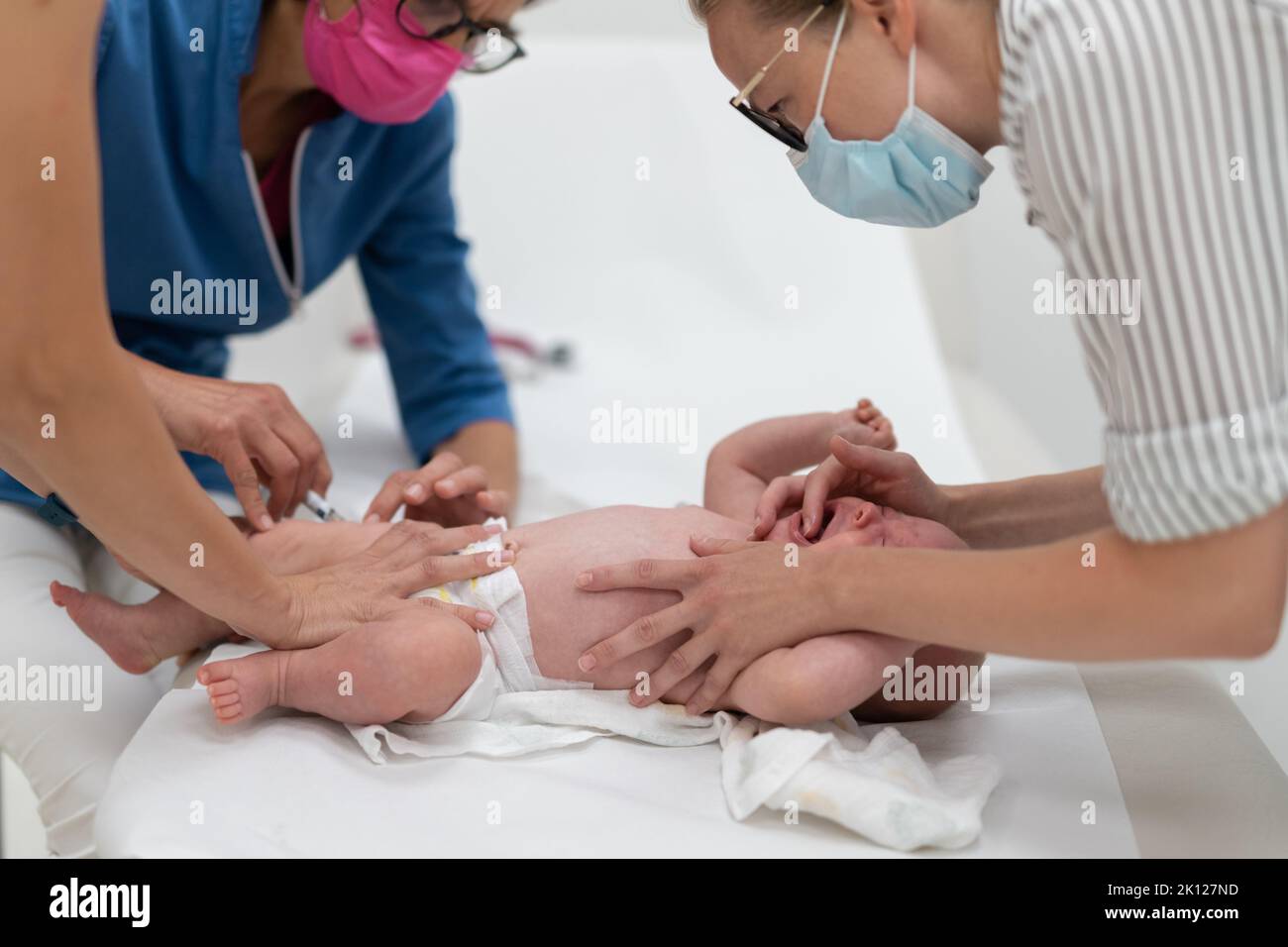 Baby beeing vaccinated by pediatrician in presence of his mother. Preventive vaccination against Diphtheria, whooping cough, tetanus, hepatitis Stock Photo