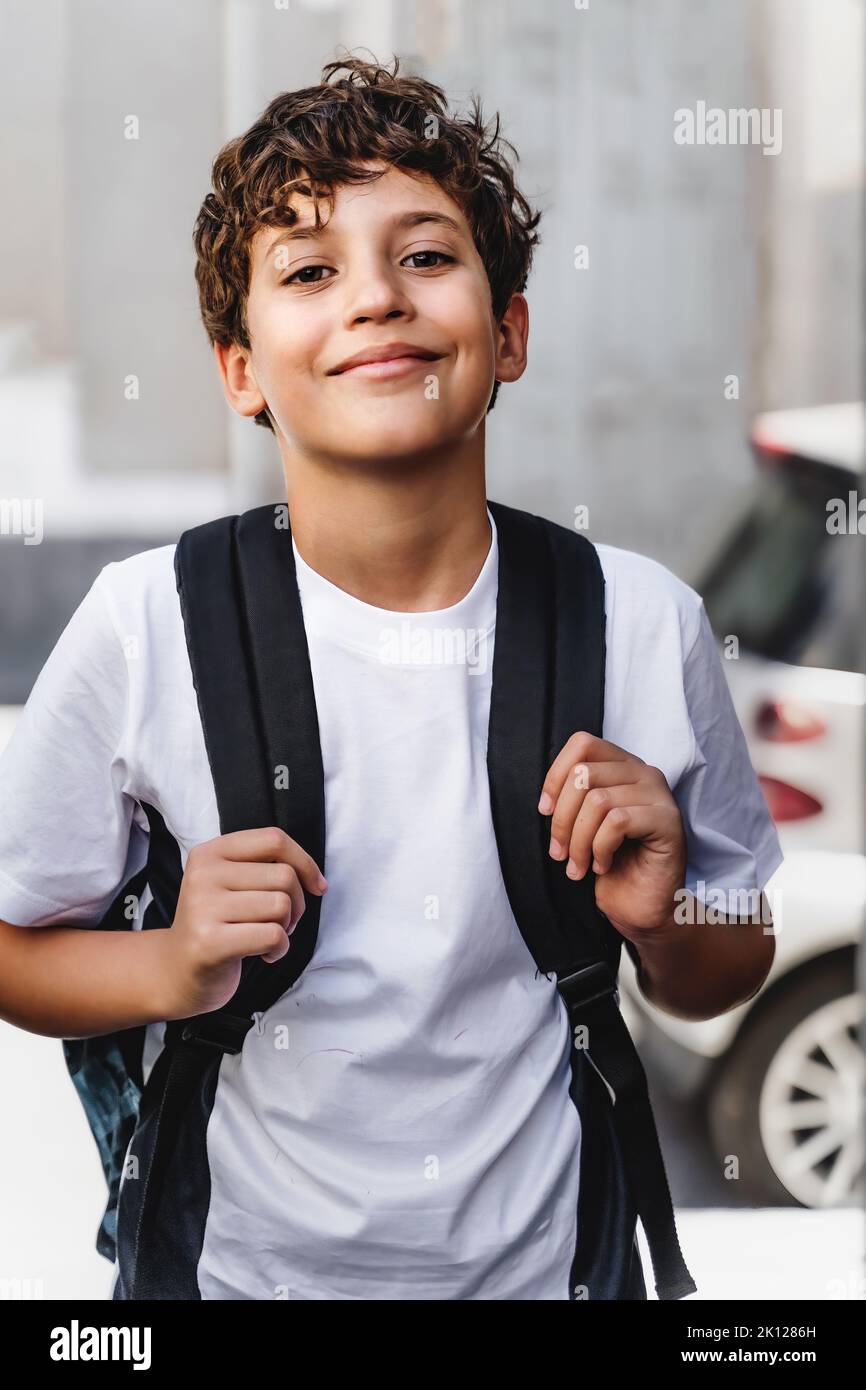 Cute handsome schoolboy with backpack going to school, urban street portrait - people lifestyle concept Stock Photo