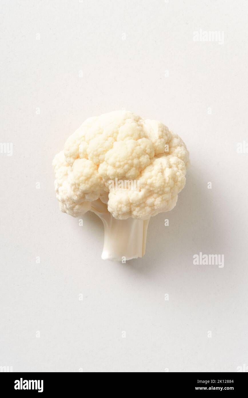 Detail of a piece of cauliflower on white table. Top view. Vertical composition. Stock Photo
