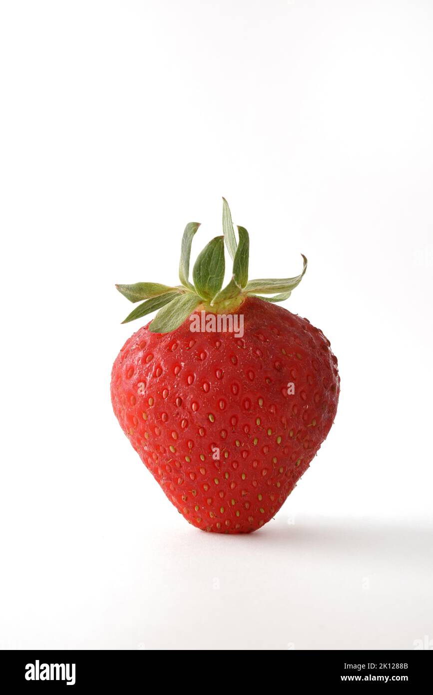 Detail of strawberry on white table with white isolated background. Front view. Vertical composition. Stock Photo