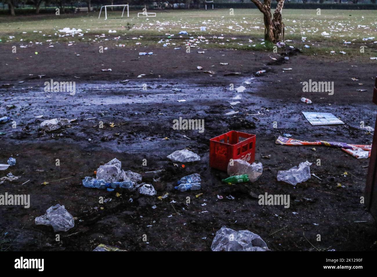 a-coca-cola-branded-soda-crate-is-seen-on-a-field-littered-with-plastic