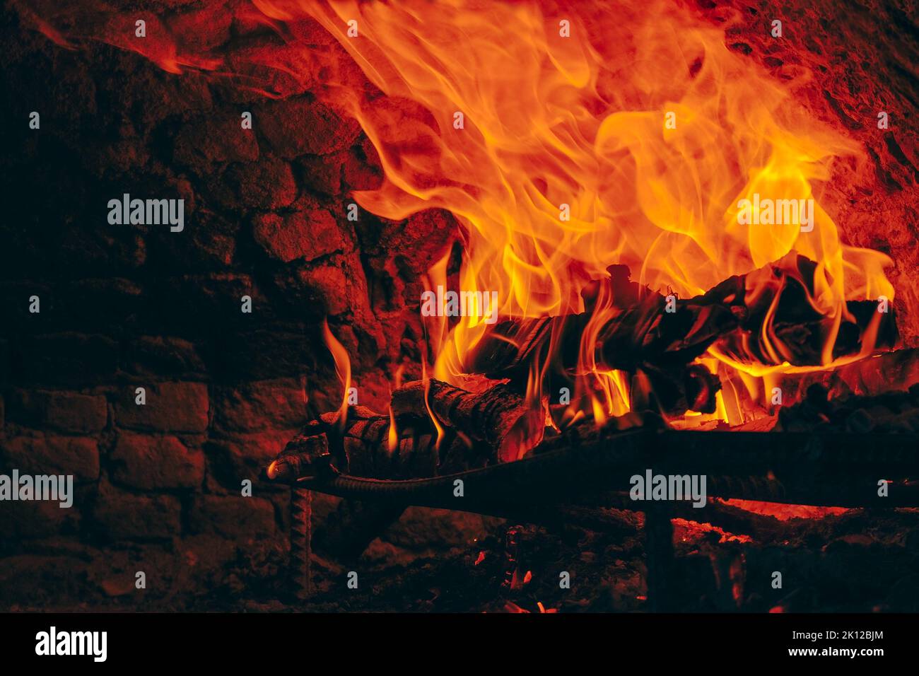 Wood fire in yellow and red colors burning in stone oven, copy space. Stock Photo