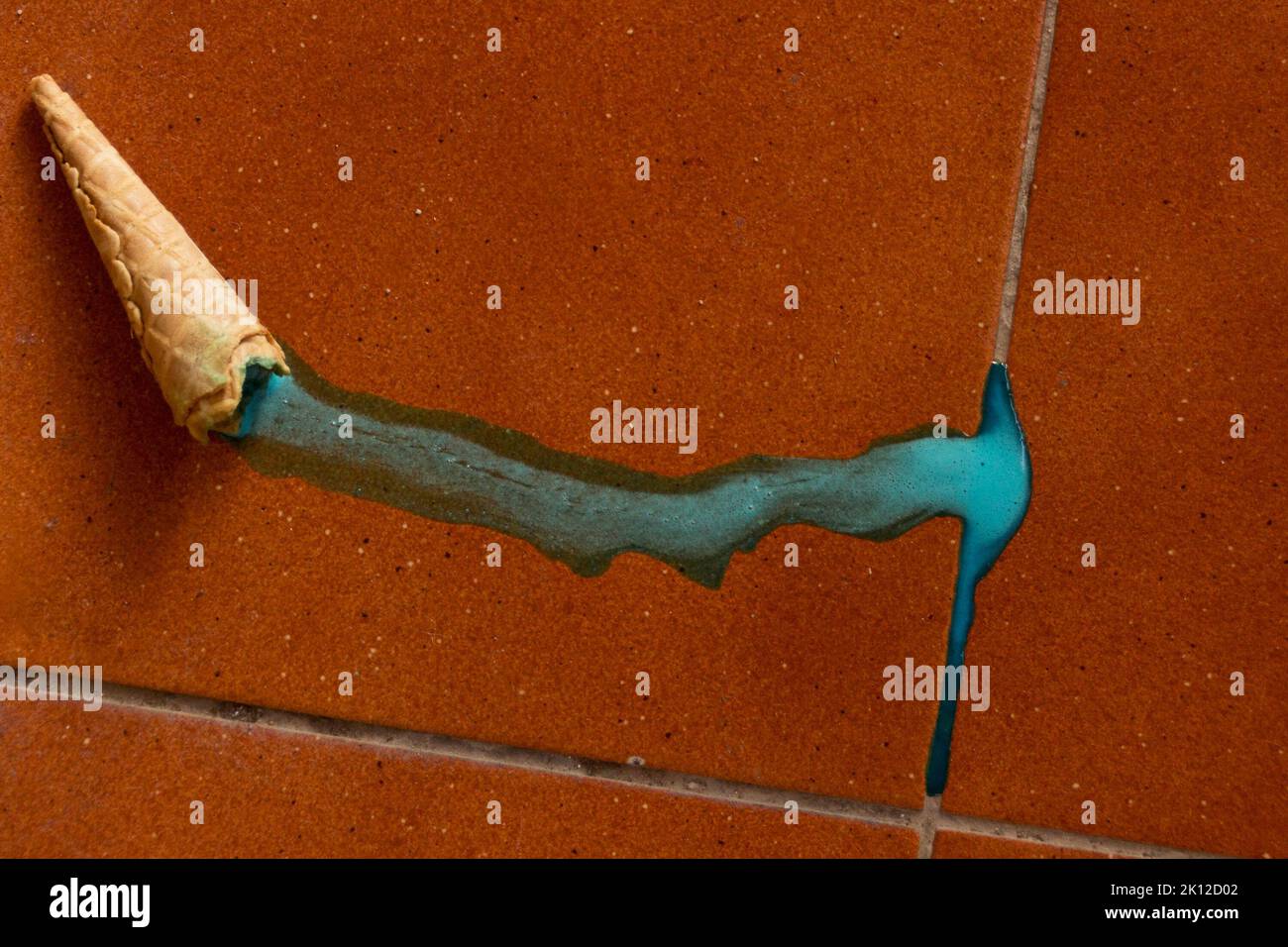 A cone with melted blue ice cream lying on the floor Stock Photo - Alamy